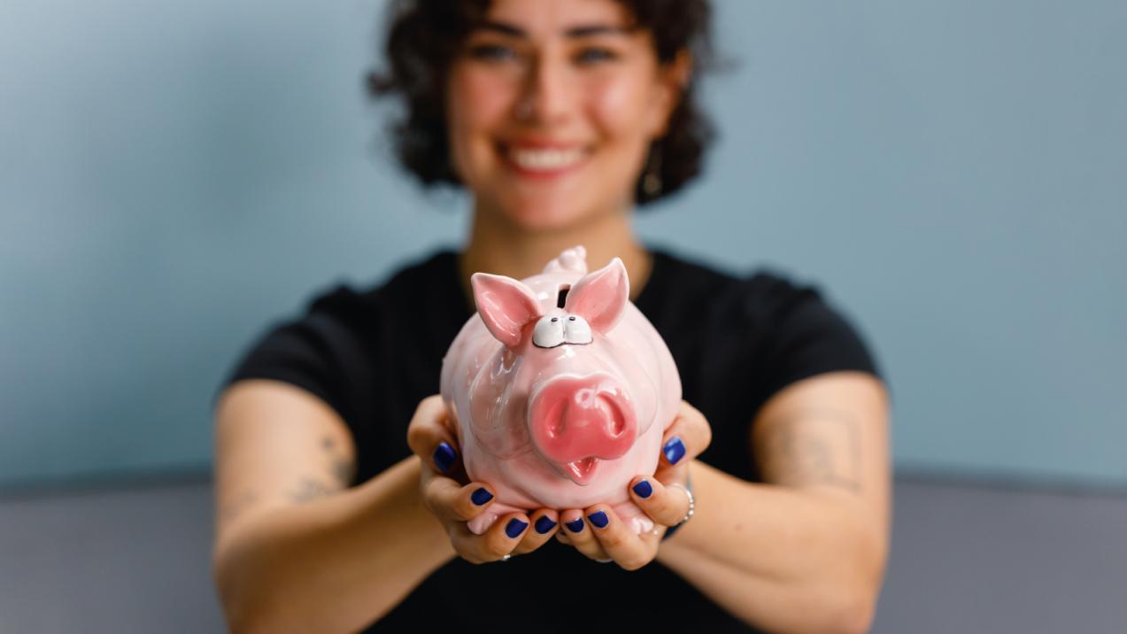 Foto von einer Studentin mit einem Sparschwein